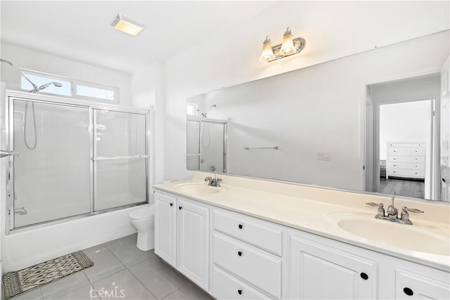 full bathroom with tile patterned floors, vanity, toilet, and combined bath / shower with glass door