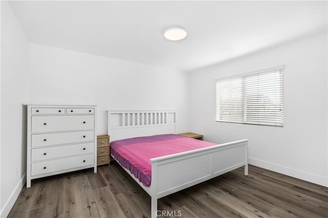 bedroom with dark hardwood / wood-style floors