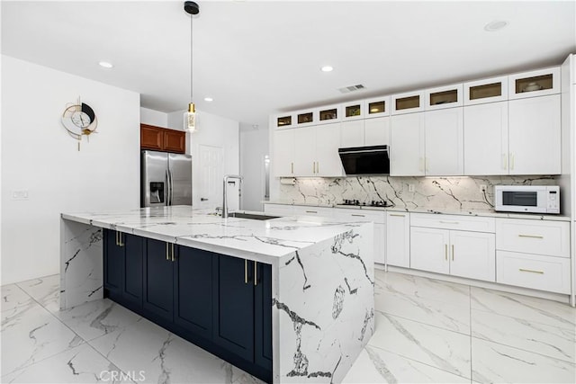 kitchen with pendant lighting, white cabinetry, sink, stainless steel fridge with ice dispenser, and a spacious island