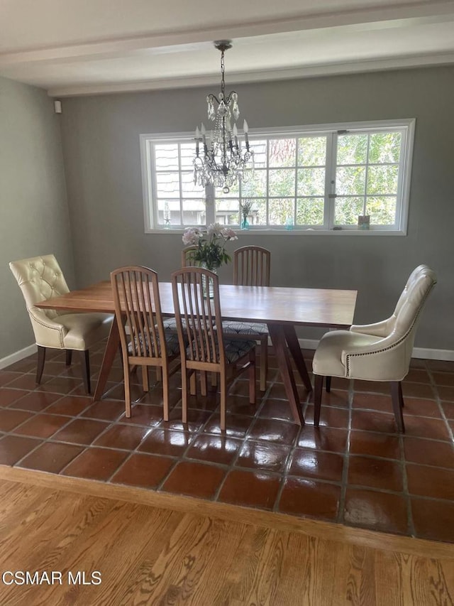 dining room featuring dark tile patterned flooring and an inviting chandelier