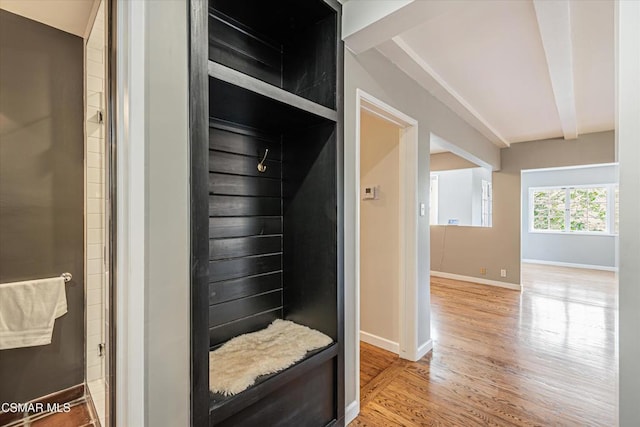 mudroom with beamed ceiling and light hardwood / wood-style floors