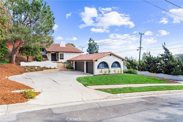 mediterranean / spanish house with a garage and a front yard