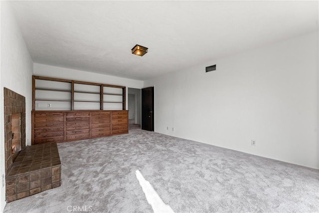 unfurnished bedroom featuring carpet and a brick fireplace