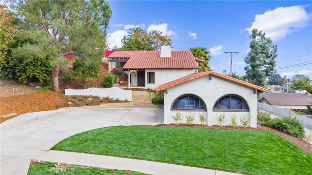 mediterranean / spanish house featuring a front lawn