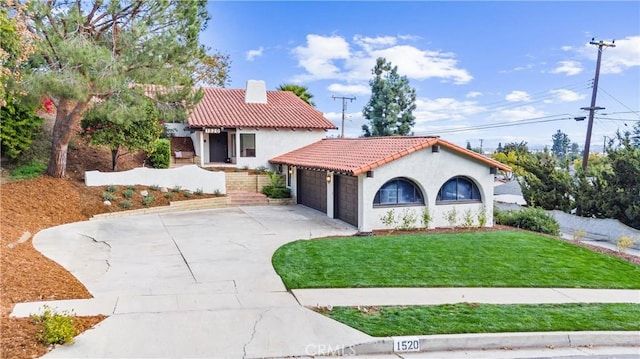 mediterranean / spanish-style home featuring a garage and a front yard