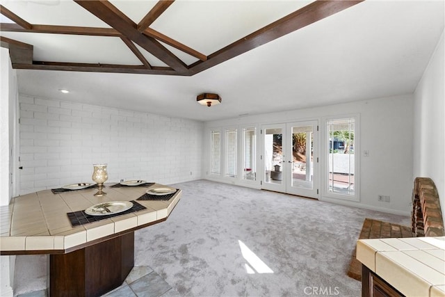 carpeted living room with vaulted ceiling with beams and french doors