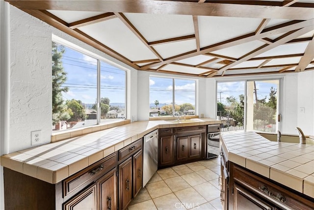 kitchen with dishwasher, dark brown cabinets, tile counters, and light tile patterned floors