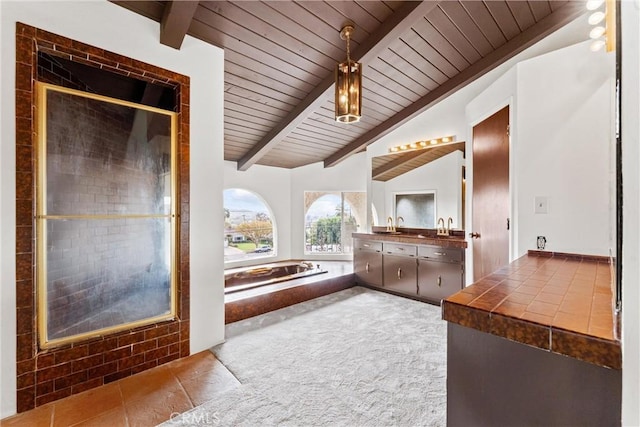 bathroom with vanity, vaulted ceiling with beams, a relaxing tiled tub, and wooden ceiling