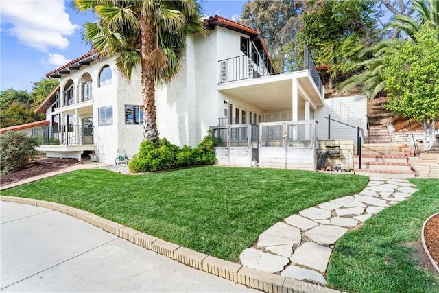 view of property exterior with a balcony and a lawn