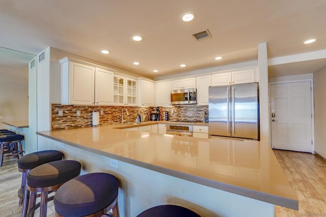 kitchen featuring white cabinetry, stainless steel appliances, and kitchen peninsula