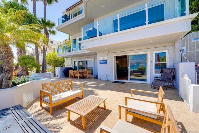 rear view of house featuring a balcony and a patio area