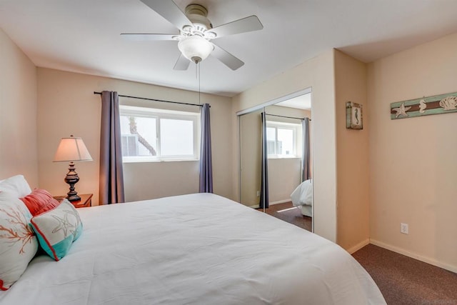 bedroom with dark colored carpet, ceiling fan, and a closet