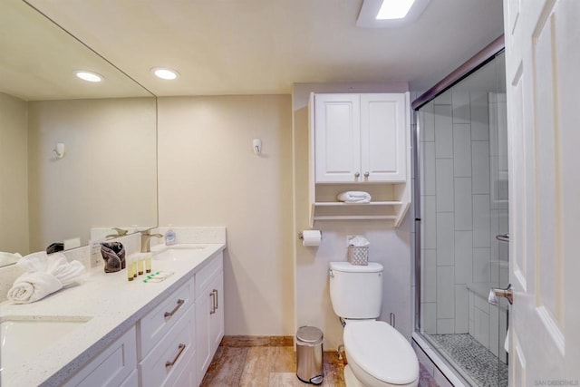 bathroom with walk in shower, vanity, toilet, and wood-type flooring