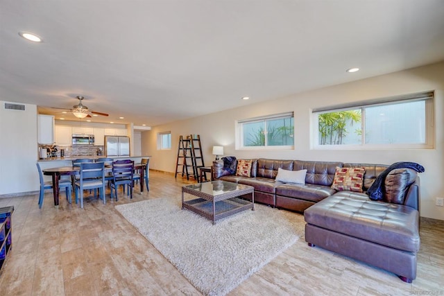 living room featuring light hardwood / wood-style flooring and ceiling fan