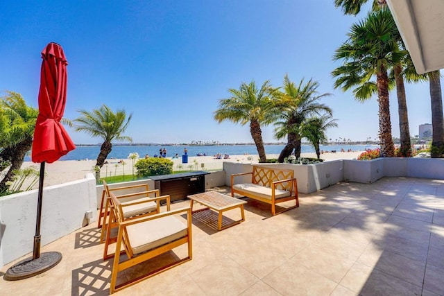 view of patio featuring a water view, an outdoor hangout area, and a jacuzzi