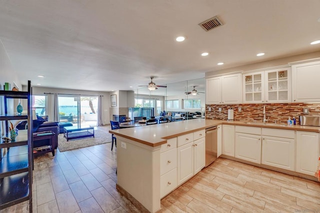 kitchen with dishwasher, white cabinetry, sink, and kitchen peninsula