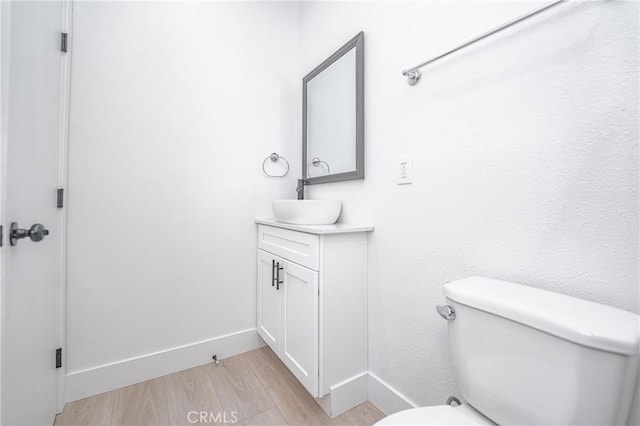 bathroom with hardwood / wood-style flooring, vanity, and toilet