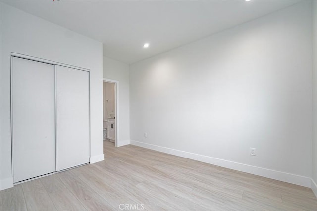 unfurnished bedroom featuring light wood-type flooring and a closet