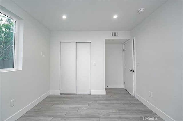 unfurnished bedroom featuring light hardwood / wood-style floors and a closet