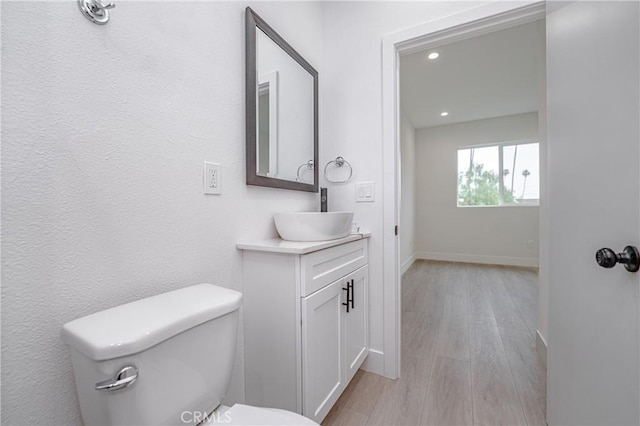 bathroom with vanity, wood-type flooring, and toilet