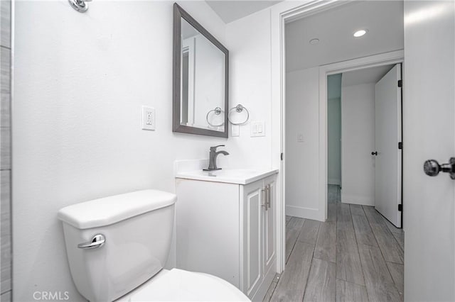 bathroom featuring vanity, hardwood / wood-style floors, and toilet