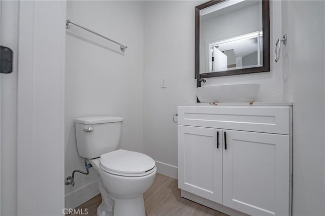 bathroom with vanity, toilet, and wood-type flooring