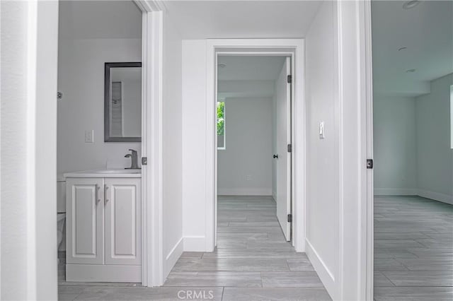 hallway featuring sink and light wood-type flooring