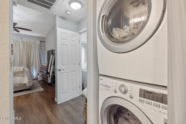 washroom featuring hardwood / wood-style flooring, ceiling fan, and stacked washer / drying machine