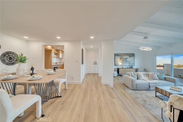 living room with light hardwood / wood-style flooring, lofted ceiling with beams, and beverage cooler