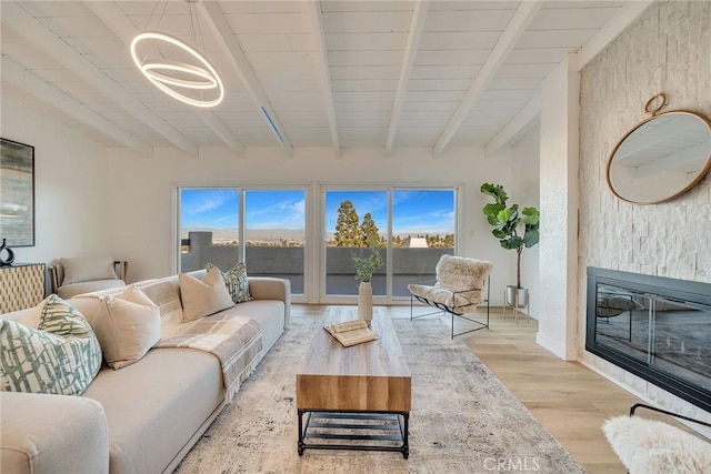 living room featuring wood ceiling, beam ceiling, a chandelier, and light wood-type flooring