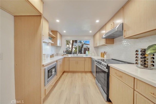 kitchen featuring sink, light hardwood / wood-style flooring, appliances with stainless steel finishes, tasteful backsplash, and light brown cabinetry