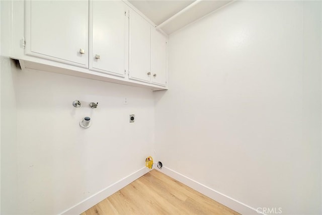 laundry room featuring gas dryer hookup, cabinets, light wood-type flooring, washer hookup, and hookup for an electric dryer