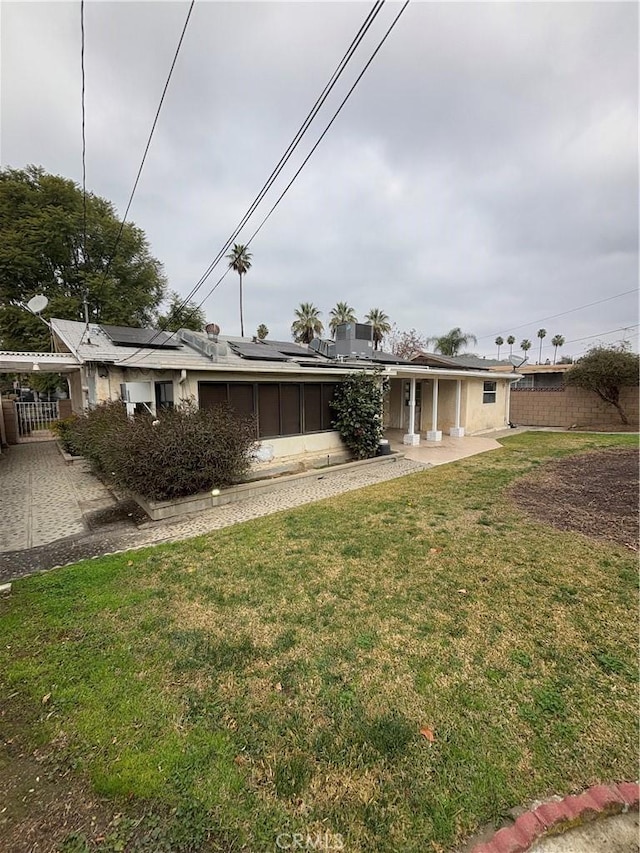 exterior space with a front yard and solar panels