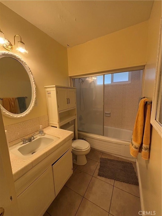 full bathroom featuring vanity, tiled shower / bath combo, tile patterned floors, and toilet