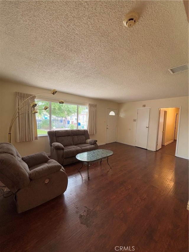 living room featuring dark hardwood / wood-style floors and a textured ceiling