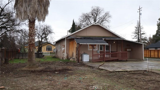 back of property featuring a wooden deck and a patio area