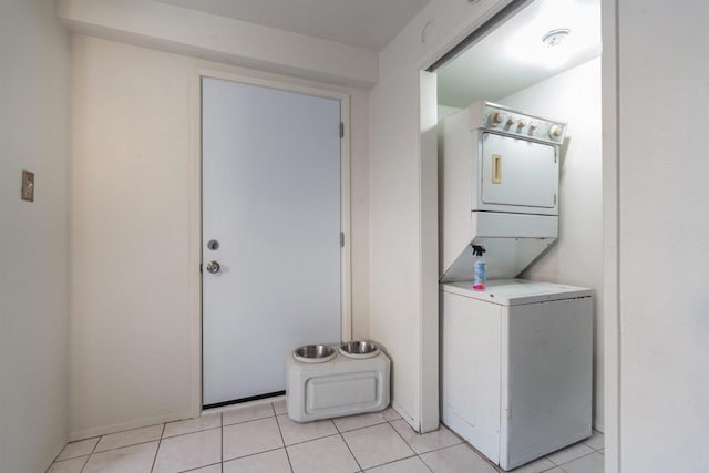 laundry area with stacked washer and dryer and light tile patterned floors