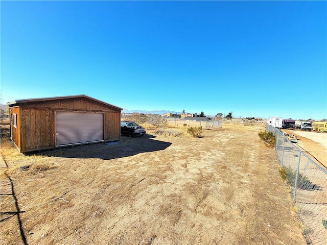 view of yard featuring a rural view and a garage