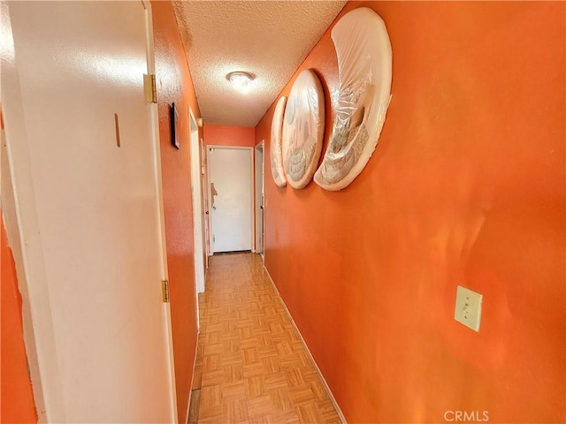 hall featuring light parquet flooring and a textured ceiling