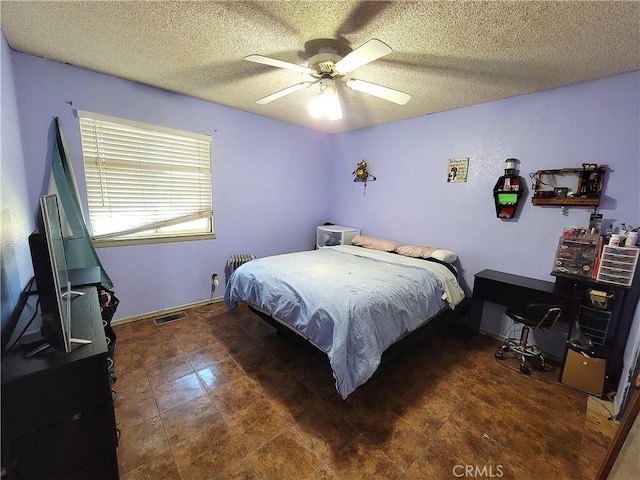 bedroom with ceiling fan and a textured ceiling