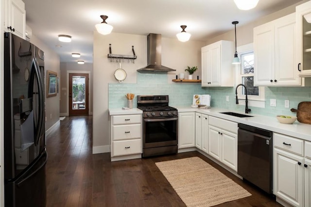 kitchen with white cabinetry, sink, hanging light fixtures, black appliances, and wall chimney exhaust hood