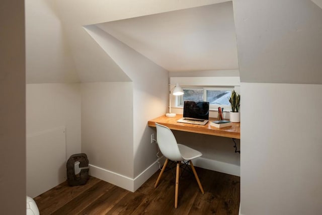 home office with dark hardwood / wood-style flooring, built in desk, and vaulted ceiling