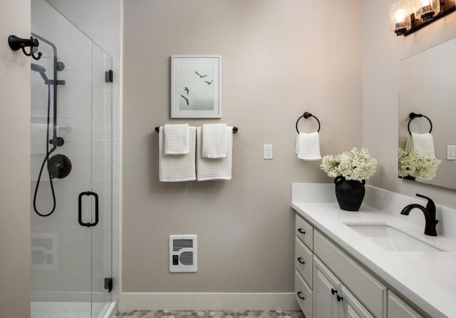 bathroom with vanity, heating unit, and an enclosed shower