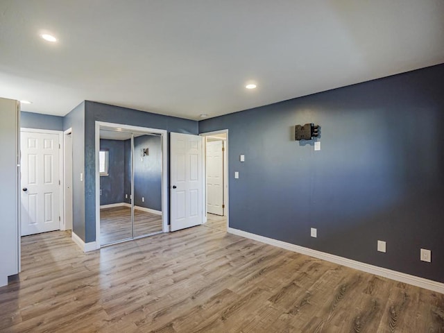 unfurnished bedroom with light hardwood / wood-style floors and a closet