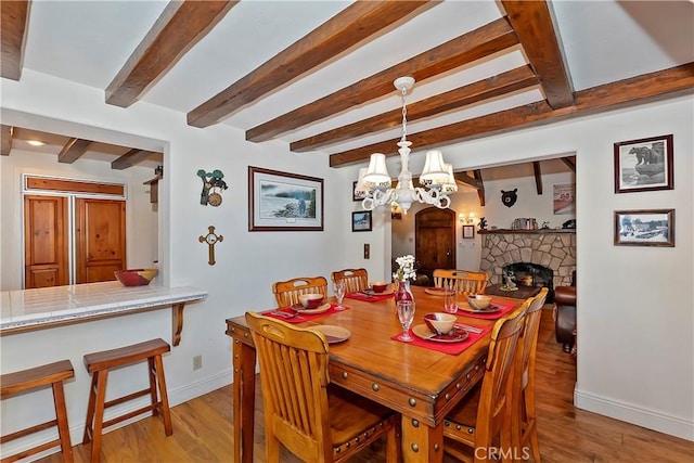 29223 Pigeon Hawk Ln, Lake Arrowhead, CA 92352 - dining space featuring light wood finished floors, beam ceiling, a fireplace, and a chandelier