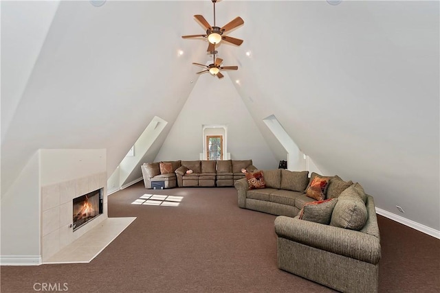 living room featuring a tiled fireplace, lofted ceiling, and carpet flooring