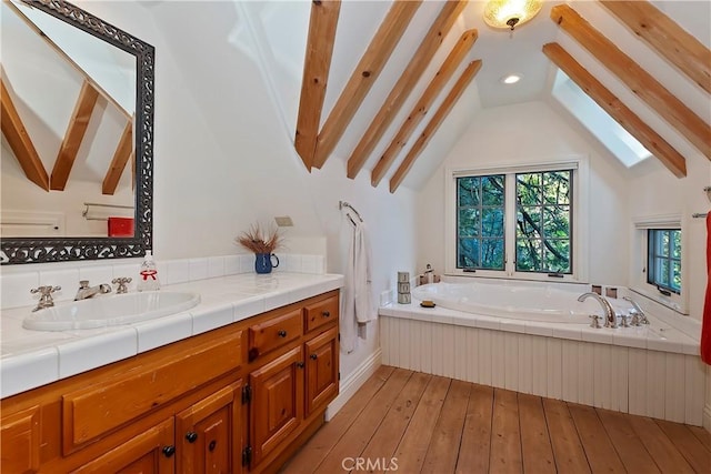 29223 Pigeon Hawk Ln, Lake Arrowhead, CA 92352 - full bathroom featuring hardwood / wood-style floors, vanity, a garden tub, and a skylight