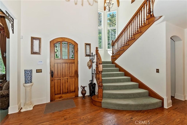 29223 Pigeon Hawk Ln, Lake Arrowhead, CA 92352 - foyer entrance with a high ceiling, wood finished floors, stairway, arched walkways, and a chandelier