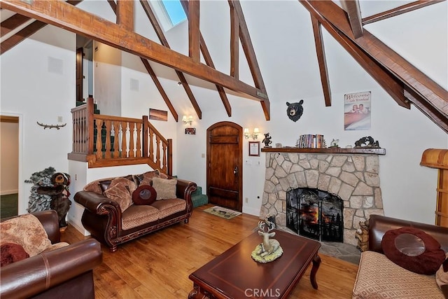 living room featuring hardwood / wood-style flooring, a fireplace, high vaulted ceiling, and beamed ceiling