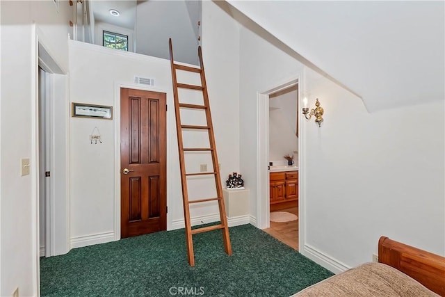 carpeted entryway featuring a high ceiling